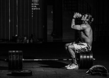 Homem tomendo suplemento l-carnitina na academia