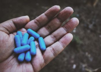 Capsulas azuis de aminoácidos na pala da mão