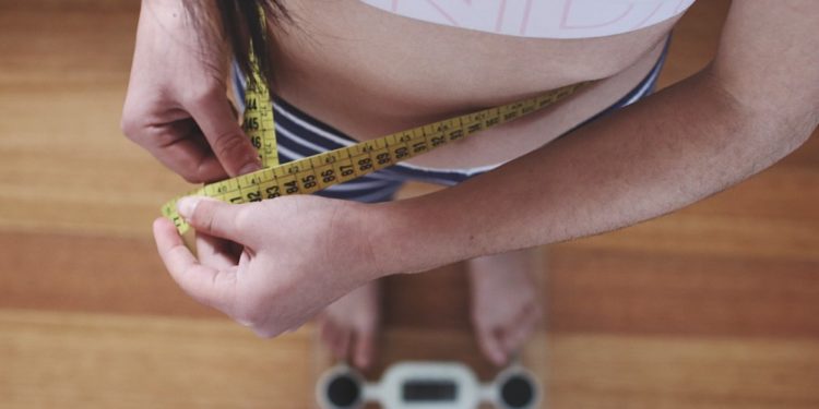 Melhores suplementos para emagrecer, mulher medindo a cintura