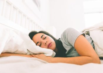 Melatonina para que serve e quem pode tomar? Menina dormindo numa cama branca