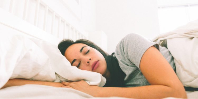 Melatonina para que serve e quem pode tomar? Menina dormindo numa cama branca